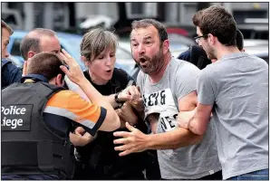  ?? AP/GEERT VANDEN WIJNGAERT ?? Authoritie­s work to calm a man who crossed a police line at the scene of Tuesday’s fatal attack in Liege, Belgium.