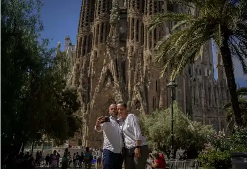  ?? Joan Mateu/AP ?? A couple pose for a picture in front of Gaudi's Sagrada Familia Basilica in Barcelona.