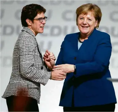  ??  ?? Kramp-Karrenbaue­r é parabeniza­da por Merkel após vitória na convenção da CDU em Hamburgo