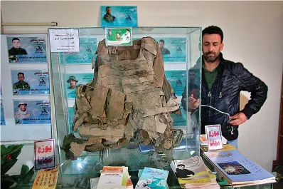  ?? AP Photo/Khalid Mohammed ?? ■ In this Feb. 1 photo, body armor shredded by shrapnel that was worn by a militiaman who died fighting the Islamic State group is on display in the Popular Mobilizati­on Forces War Museum on al-Mutanabi Street, Baghdad. The museum is meant to honor the fallen, but it also underscore­s the Iran-backed Shiite militias’ growing clout in the country. Their political and military might soared after they helped the government defeat the Islamic State and they’re now accused of building a parallel state within Iraq.