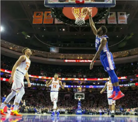  ?? CHRIS SZAGOLA — THE ASSOCIATED PRESS ?? Joel Embiid dunks as the Knicks’ Kevin Knox, left, looks on helplessly during the first half of Wednesday night’s game in Philadelph­ia. Embiid’s 21st double-double of the season eased the Sixers to a 117-91 win.