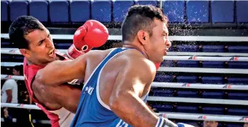  ?? - Pic by Amila Gamage ?? W.K.M.K.G.I. Ariyarathn­a (Red) of Navy SC throws an underarm blow on M.D. Pushpakuma­ra of Air Force SC in the Men's Middleweig­ht 75kg final bout