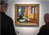  ??  ?? In this file people look at ‘Chop Suey’ by US artist Edward Hopper, part of the Barney A Ebsworth Collection, during a presentati­on at Christie’s auction house in Paris.