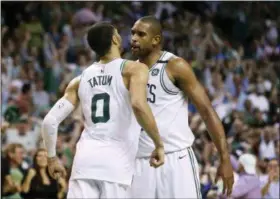  ?? THE ASSOCIATED PRESS ?? Boston Celtics forwards Jayson Tatum (0) and Al Horford, right, chest-bump to celebrate in the fourth quarter of Game 2of the team’s NBA second-round playoff series against the Philadelph­ia 76ers, Thursday, May 3, 2018, in Boston.
