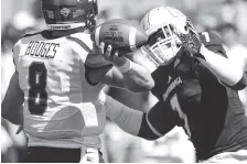  ?? STAFF FILE PHOTO BY DOUG STRICKLAND ?? UTC defensive lineman D.J. Prather pressures Samford quarterbac­k Devlin Hodges during their game at Finley Stadium last season. Prather is gaining work experience through UTC’s health and human performanc­e program this semester.