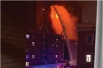  ?? AP PHOTO ?? BLAZE BATTLE
This image from a user-generated content video shows firefighte­rs spraying water on a fire at a residentia­l building in the city of Urumqi in the Xinjiang Uyghur Autonomous Region, northweste­rn China on Thursday, Nov. 24, 2022.