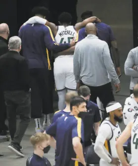  ?? Jeffrey D. Allred / Associated Press ?? Jazz guard Donovan Mitchell is helped off the court by teammates after suffering an injury in the second half. He was to undergo an MRI exam.