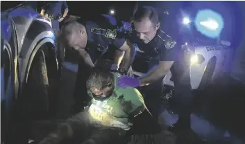  ?? LOUISIANA STATE POLICE VIA AP ?? This image from the body camera video of Louisiana State Police Trooper Dakota DeMoss shows his colleagues, Kory York (center left) and Chris Hollingswo­rth (center right) holding up Ronald Greene before paramedics arrived in 2019, outside of Monroe, La.