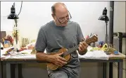  ?? LAURA SKELDING / AMERICAN-STATESMAN 2011 ?? Bill Collings plays a ukelele in his Austin shop in the spring of 2011. Collings, whose company produces 1,700 guitars a year, died Friday.