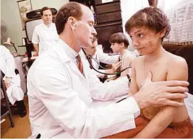  ?? Houston Chronicle file ?? Dr. Mark Kline examines a patient in 1998 in Romania, where he would go on to found a pediatric AIDS clinic.