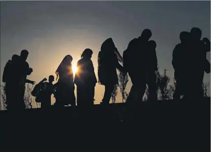  ?? LASZLO BALOGH / REUTERS ?? Refugiaos sirios e iraquíes caminan ayer en Roszke (Hungría) en dirección a Alemania