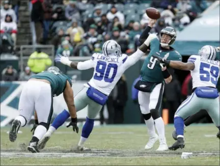  ?? CHRIS SZAGOLA — THE ASSOCIATED PRESS ?? Eagles quarterbac­k Nick Foles, here absorbing pressure from the Cowboys’ DeMarcus Lawrence Sunday, has struggled in the cold weather at the Linc recently. But frigid temps will affect visiting QBs just as much, lessening the pressure on the Eagles’...