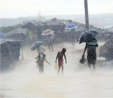  ?? MUNIR UZ ZAMAN / AFP / GETTY IMAGES FILES ?? Rohingya refugees navigate harsh rains last October in Bangladesh’s Ukhia district. The recent start of monsoon season has triggered devastatin­g floods and landslides, raising fears of disease and malnutriti­on.