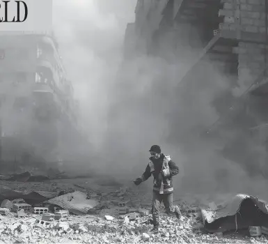  ?? ABDULMONAM EASSA / AFP / GETTY IMAGES ?? A civil defence volunteer checks the site of an airstrike in the rebel-held town of Saqba, in the Eastern Ghouta region outside of Damascus, on Friday. Another 32 civilians were killed in the sixth straight day of Syrian regime air strikes.