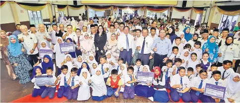  ?? — Photo by Muhammad Rais Sanusi ?? Abang Johari (third row, seventh left), Juma’ani (third row, sixth left), Sabariah (third row, fifth left), Mohamad Abu Bakar (third row, eighth left) and Azmi (third row, ninth left) in a photo-call with school uniform assistance and domestic scholarshi­ps recipients.