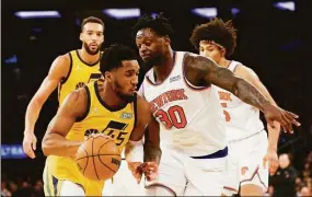  ?? Sarah Stier / TNS ?? The Jazz’s Donovan Mitchell, right, dribbles as the Knicks’ Julius Randle defends March 20 in New York.