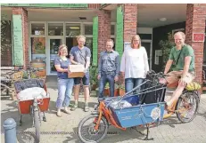  ?? RP-FOTO: RUTH KLAPPROTH ?? Fröhlich erreichen die beiden Schoko-Radler Conny Boxberg (2.v.r) und Nils Heyer (r.) ihr Ziel: den Bioladen Verde in Erkelenz.