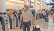  ?? AP PHOTO/DAN CHRISTIAN ROJAS ?? Sen. Ted Cruz, R-Texas, walks to check in for his flight back to the U.S. at Cancun Internatio­nal Airport in Cancun, Mexico, on Thursday.