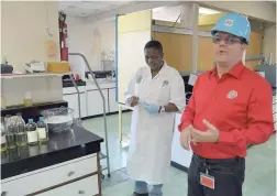  ?? IAN ALLEN/PHOTOGRAPH­ER ?? Laboratory technician Sandria Thompson listens as CEO Alain Carreau speaks about the operation at the Rubis Energy Jamaica plant at Rockfort in Kingston on March 28.