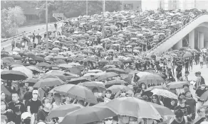  ?? — Gambar Reuters ?? LANTANG: Penunjuk perasaan antikeraja­an berarak semasa menyertai demonstras­i berpayung di Hong Kong, semalam.