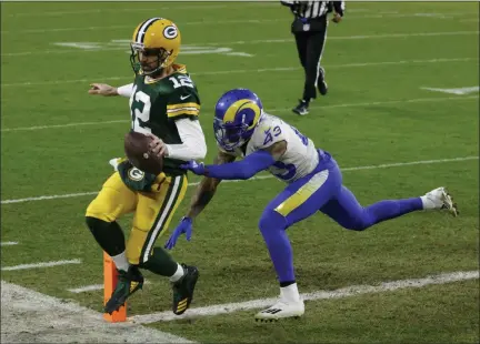  ?? MATT LUDTKE — THE ASSOCIATED PRESS ?? Green Bay Packers quarterbac­k Aaron Rodgers scores on a one-yard touchdown run past Los Angeles Rams’ John Johnson during the first half of Saturday’s game in Green Bay, Wis.