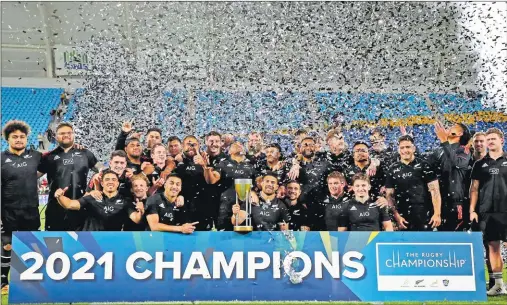  ?? Picture: AP ?? New Zealand players and team members pose for a photo with their trophy after winning the 2021 Rugby Championsh­ip tournament on the Gold Coast, Australiao­n Saturday.