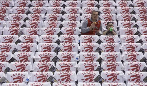  ?? RICK MADONIK/TORONTO STAR ?? Joel Stevenson and son Cree, 5, were among the early arrivals Wednesday night, and were greeted by a sea of Raptors T-shirts before the season opener against the Indiana Pacers.