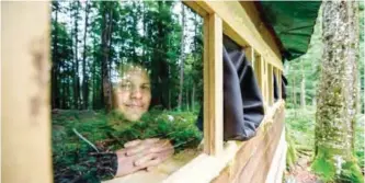  ?? — AFP photos ?? Bear observatio­n tour organizer Miha Mlakar poses for a photo in one of his bear watching hide in the forest above the small village of Markovec, some 50 km south of Ljubljana.