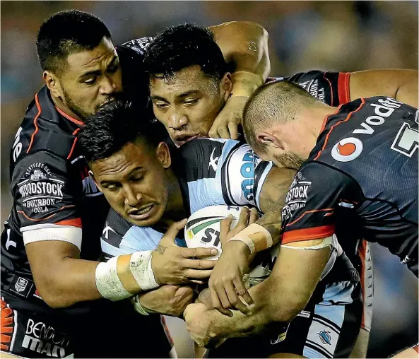  ??  ?? The Warriors’ defence swallows up the Sharks’ Ben Barba during their clash in Sydney last night.
