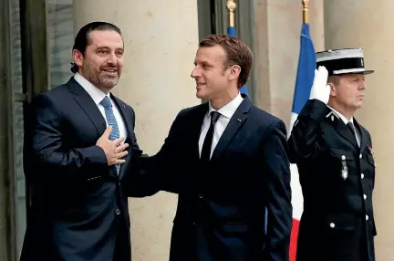  ?? PHOTO: REUTERS ?? French President Emmanuel Macron, right, and Saad al-Hariri react on the steps of the Elysee Palace in Paris, France.