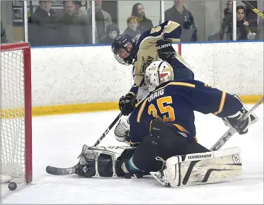  ?? PETE BANNAN — MEDIANEWS GROUP ?? West Chester Rustin’s Aiden Harris (56) puts puts the puck past Unionville goalie Keigan Craig in the second period Wednesday night.