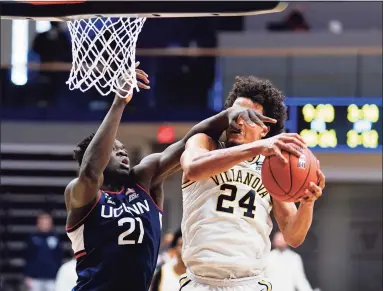  ?? Matt Slocum / Associated Press ?? Villanova’s Jeremiah Robinson-Earl, right, pulls in a rebound against UConn’s Adama Sanogo during the first half on Saturday.