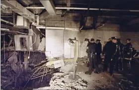  ?? AP PHOTO/ RICHARD DREW, FILE ?? New York City police and firefighte­rs inspect the bomb crater inside an undergroun­d parking garage of New York’s World Trade Center on Feb. 27, 1993, the day after an explosion tore through it.