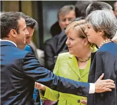  ?? Foto: Emmanuel Dunand, afp ?? Eine gehört bald nicht mehr dazu: Theresa May (rechts). Einer ist neu und zieht sofort das Interesse auf sich: Frankreich­s Präsident Emmanuel Macron (links). Und eine bleibt im Zentrum: Kanzlerin Angela Merkel.