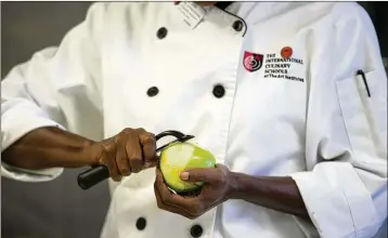  ?? JASON GETZ/AJC FILE ?? A student works on preparing dinner in the kitchen at the Art Institute of Atlanta in 2016. The school announced it was closing, effective at the end of last week, along with the Miami Internatio­nal University of Art & Design.