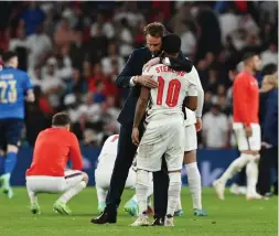  ?? (Reuters) ?? ENGLAND MANAGER Gareth Southgate consoles forward Raheem Sterling on the pitch after the Three Lions were beaten by Italy after a dramatic penalty shootout in Sunday night’s Euro 2020 final at Wembley Stadium.