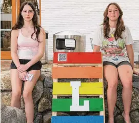  ?? Jarret Liotta / Hearst Connecticu­t Media ?? McKenna Rooney, 14, left, and Charlotte Halliwell, 14, pose with one of the signs from the Wilton Pride celebratio­n in June at the Village Green and Wilton Library. They are part of a team of four Girl Scouts in Wilton who earned their Silver Award by bringing awareness and acceptance to the LGBTQ+ community by organizing a Wilton Pride event.