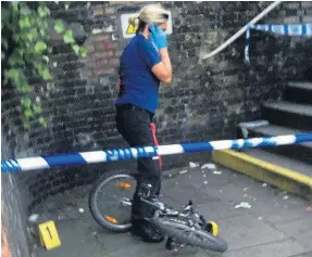  ??  ?? Police woman guards the cycle found at the scene of the abduction alarm