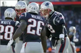  ?? ELISE AMENDOLA — THE ASSOCIATED PRESS ?? Patriots quarterbac­k Tom Brady, right, celebrates a touchdown run by running back Sony Michel during the first half of Sunday’s AFC divisional playoff game against the Los Angeles Chargers. The Patriots won, 41-28.