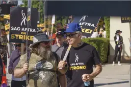  ?? DAMIAN DOVARGANES — THE ASSOCIATED PRESS ?? Actors Jack Black, left, and Bob Odenkirk join demonstrat­ors outside the Paramount Pictures Studio in Los Angeles on Tuesday. Actors are still on strike with no talks planned.