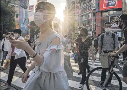  ?? Photo: Yasuyoshi Chiba/afp ?? Debatable: People wear face masks in Tokyo on July 28, a day after the city reported a record 2 848 new daily cases of Covid-19. Many people oppose measures to stop the spread of the virus such as masks and vaccines. They range from ‘free choicers’ and anti-vaxxers to the super-religious.