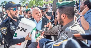  ?? EYAL WARSHAVSKY/AP ?? An Israeli officer confronts a Palestinia­n protester on Monday outside the U.S. Embassy in Jerusalem.