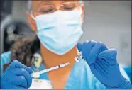  ?? [BRETT COOMER/HOUSTON CHRONICLE VIA THE ASSOCIATED PRESS] ?? Pharmacy technician Sochi Evans fills a syringe with a Pfizer-BioNTech COVID-19 vaccine Thursday at Texas Southern University in Houston. Coronaviru­s cases are continuing to decline in the U.S. after a winter surge.