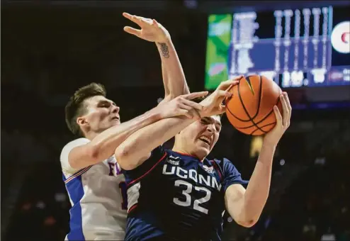 ?? Alan Youngblood / Associated Press ?? Florida’s Colin Castleton, left, and UConn’s Donovan Clingan (32) fight for a rebound during the second half of an on Wednesday in Gainesvill­e, Fla.