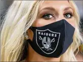  ?? Ethan Miller / Getty Images ?? A Las Vegas Raiders cheerleade­r wears a mask at a preseason game. The Raiders have taken the lead on fan vaccinatio­n.