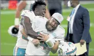  ?? DAVID BECKER / AP ?? Miami Dolphins wide receiver Isaiah Ford, left, celebrates with quarterbac­k Ryan Fitzpatric­k after defeating the Las Vegas Raiders in a game last Saturday in Las Vegas.