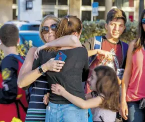  ?? EFE ?? Una estudiante de la escuela secundaria Marjory Stoneman Douglas es consolada por sus familiares después del atentado/