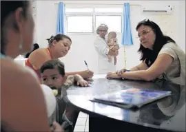  ??  ?? HEALTH workers talk to the family of a 4-month-old not born with microcepha­ly. The study seeks to assess the severity of the Zika risk, among other issues.