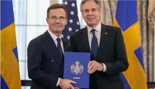  ?? ?? Secretary of State Antony Blinken is seen with Swedish Prime Minister Ulf Kristersso­n holding Sweden's NATO Instrument­s of Accession