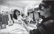  ?? XU KANGPING / FOR CHINA DAILY ?? An outbound Chinese tourist pays with Alipay at the checkout of
a shopping mall in Sydney.